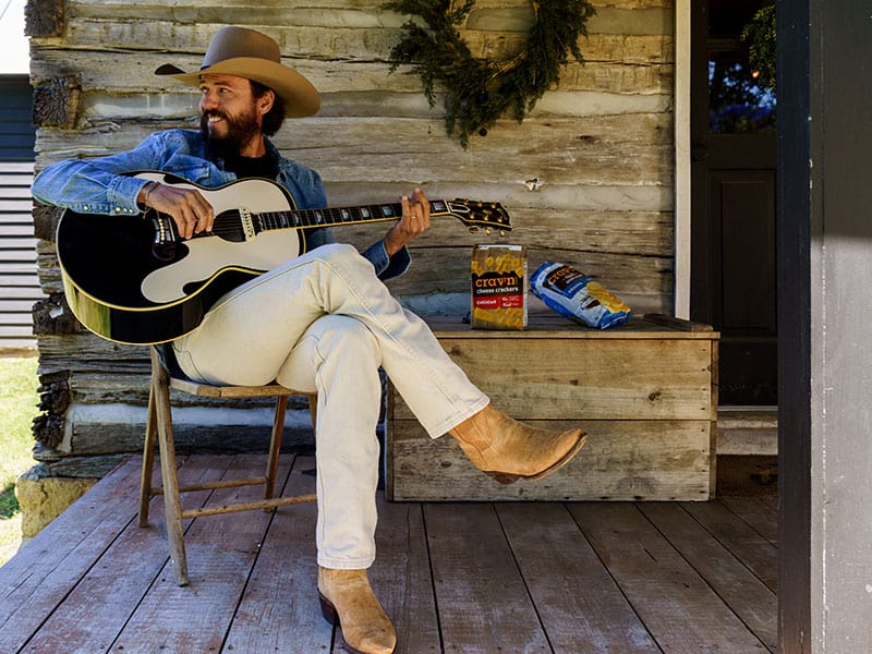 Country singer Chris Janson on the porch enjoying Crav'n Flavor snacks